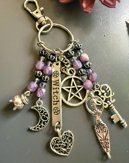 Witch Engraved Keychain Bag Charm with Iridescent Purple Beads and Witchy Charms.