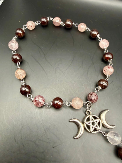 Witch’s Rosary: Strawberry Quartz, Garnet, Triple Moon, and Witch’s Knot Charm.